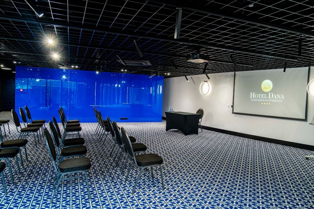 Sala konferencyjna Hotelu Dana w Szczecinie z ekranem i ustawieniem krzeseł